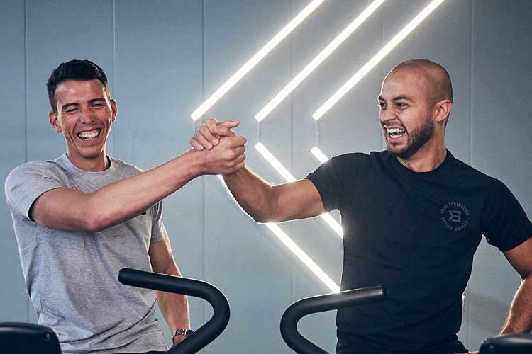 To glade medlemmer tar en high five på treningssenteret