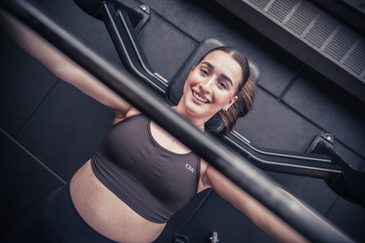 Jente på treningssenteret som trener armer