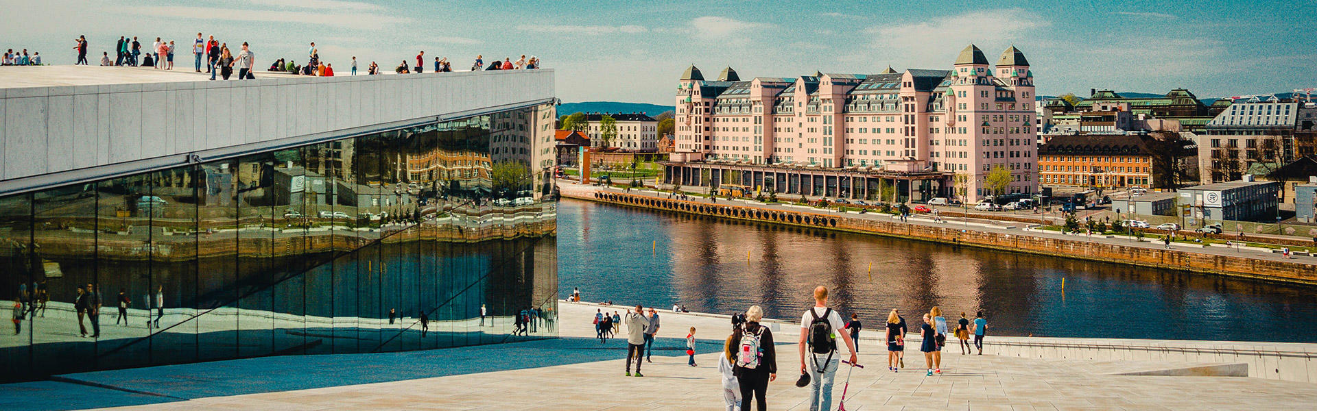 Et bilde av Oslo med mennesker i forgrunnen og bygninger og bylandskap i bakgrunnen
