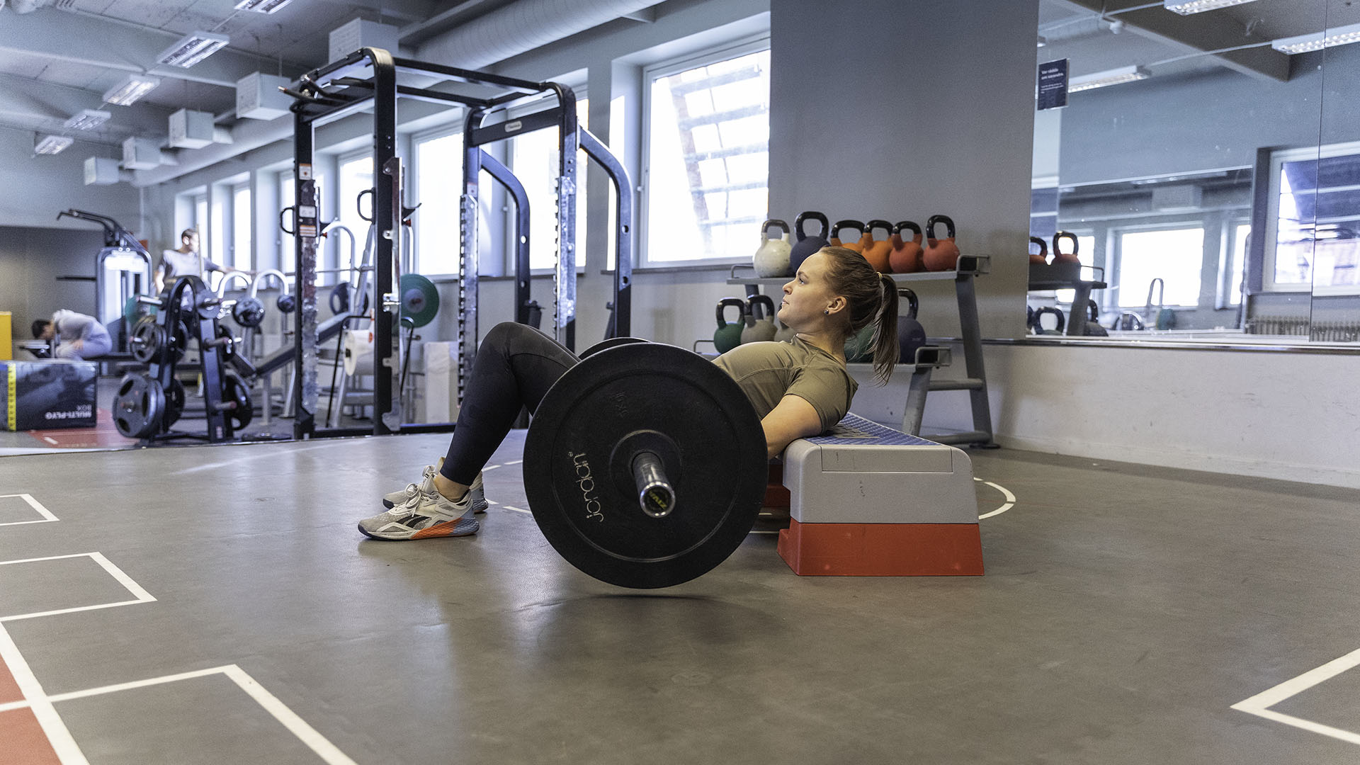 Kvinna gör hip thrusters med skivstång
