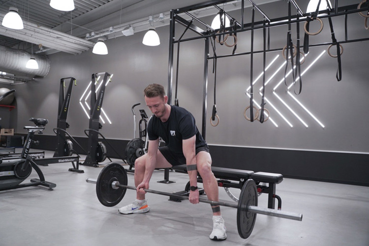Mann på treningssenteret gjør sumo squats