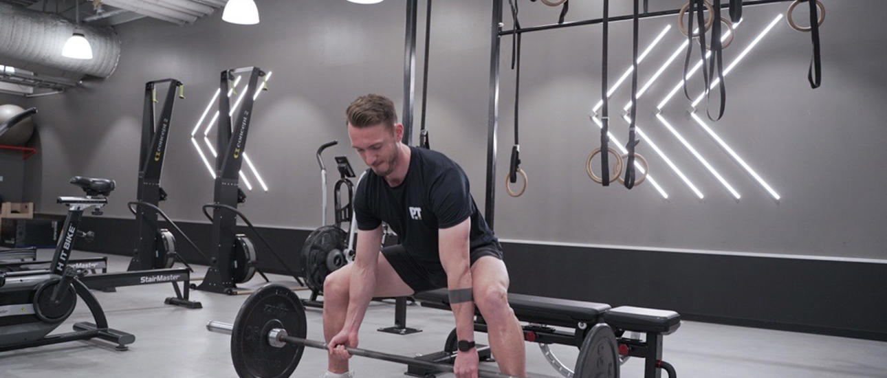 Mann på treningssenteret gjør sumo squats